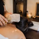 Massage aux huiles chaudes : huile tiède sur l’épaule, serviette chaude en spa